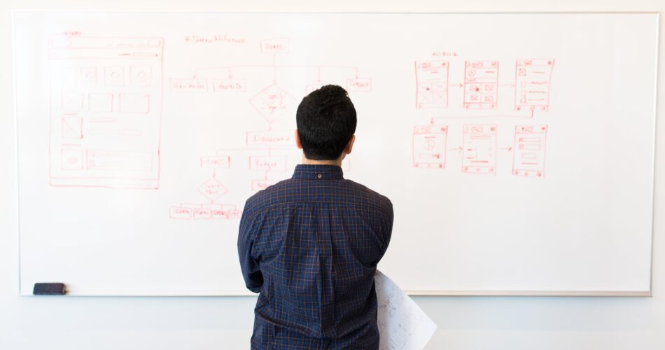 man standing infront of white board